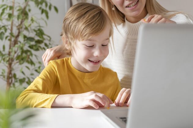 娱乐笑笑母子在家使用笔记本电脑孩子女人年轻人