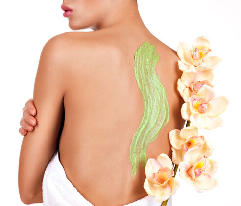 花女人关心身体的皮肤使用化妆品擦洗的背部健康自然毛巾