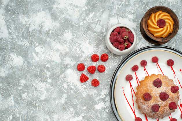 覆盆子顶视图浆果蛋糕白色椭圆形板饼干碗与树莓在灰色表面自由空间草莓盘子浆果蛋糕