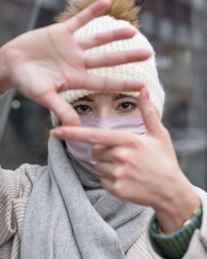 病毒戴着医用面罩的女士用手制作镜框的正面图大流行个人人类