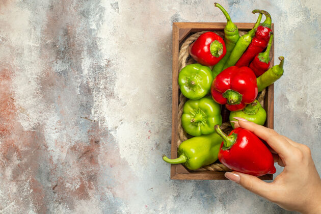 西红柿顶视图红椒和青椒在木箱里辣椒在女人手上裸体复制的地方顶部青椒和红椒甜椒