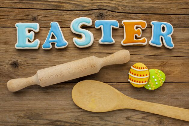 平铺顶视图彩色复活节彩蛋与擀面杖和木勺鸡蛋擀面杖彩色