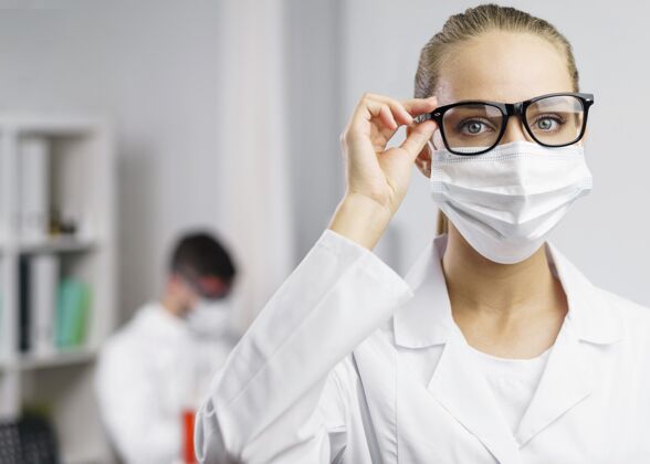 试管戴着医学面具的女科学家在实验室的画像实验室外套发明家女人