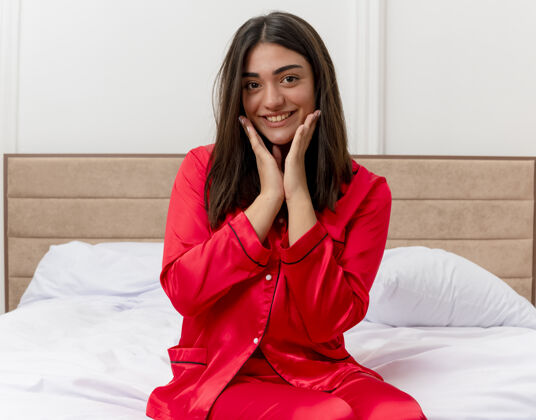 女人穿着红色睡衣在床上放松的年轻美女坐着漂亮睡衣