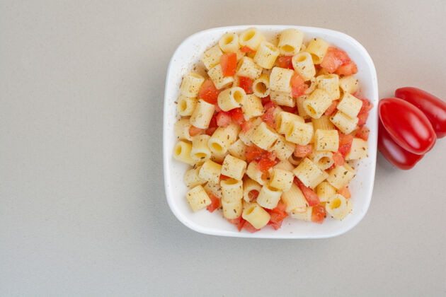 通心粉开胃的潘恩面食 加香料和番茄片放在白色盘子里食物番茄面食