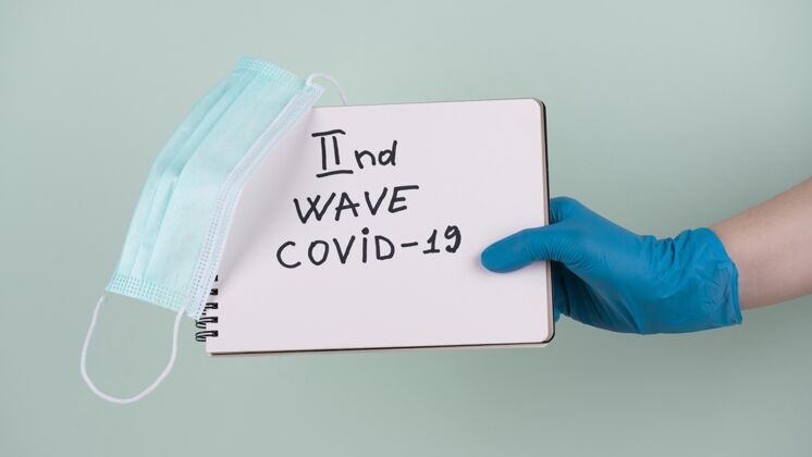 流行病手拿着手术手套拿着笔记本说第二波covid防护第二流行病