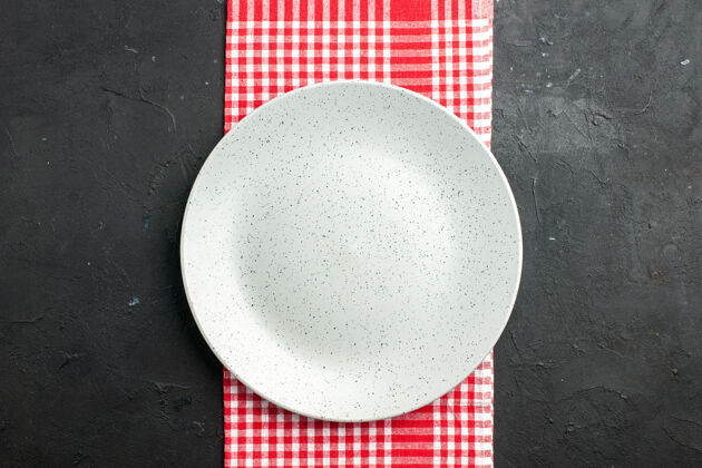 圆形顶视图白色圆板上的红色和白色方格餐巾上的黑色桌子复制的地方玻璃板深色