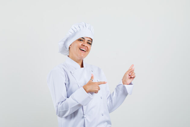 食品一位身穿白色制服的女厨师指着旁边 看上去很高兴服务柜台制服