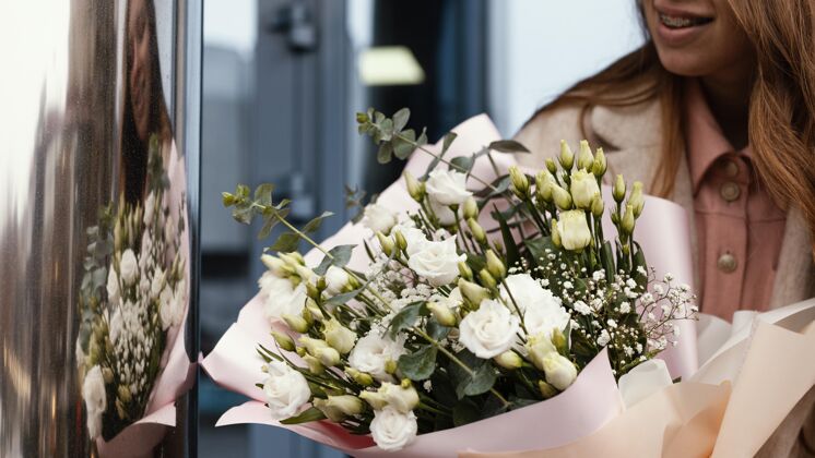 女人优雅女子手持一束鲜花的正面视图户外季节花朵