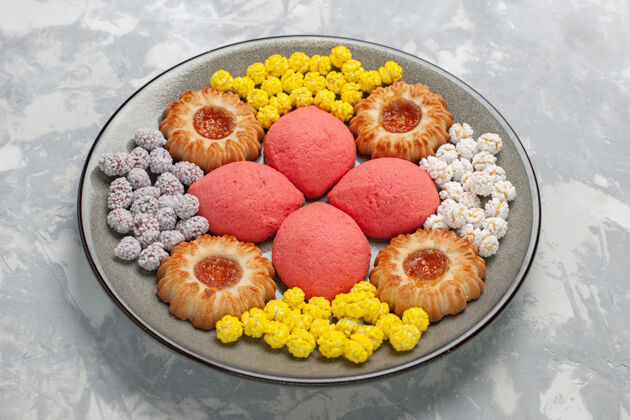 盘子正面图粉色蛋糕 白色表面的盘子里有糖果和饼干甜点茶蛋糕