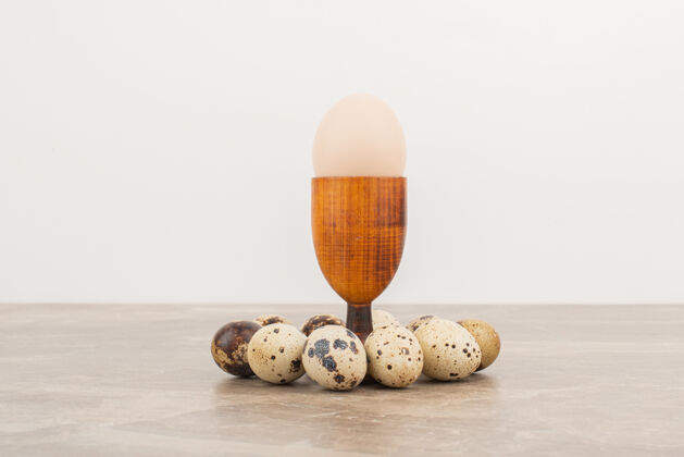 鸡蛋鹌鹑蛋周围的蛋在白色的表面健康营养丰富鹌鹑