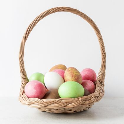 手工制作五颜六色的复活节彩蛋在干草篮前视图文化鸡肉复活节彩蛋