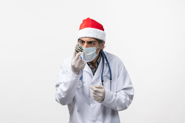 医生正面图白色地板上有新年树玩具的男医生病毒健康病毒听诊器男医生药品