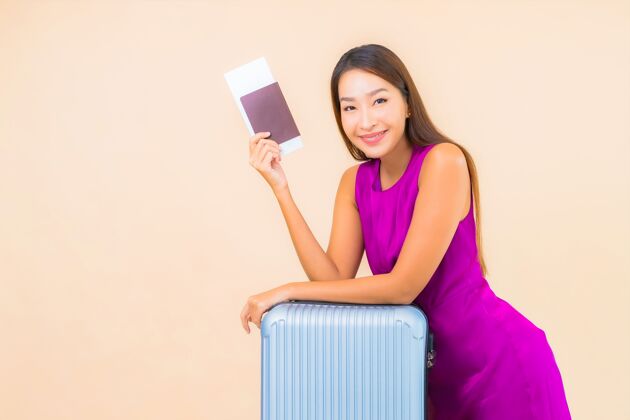 粉色在彩色背景上描绘美丽的亚洲年轻女子 带着行李和机票旅行微笑度假