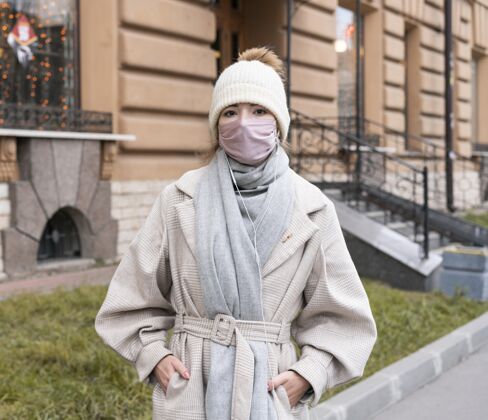 妇女戴着医用面罩的城市妇女的正面图病毒公民大流行