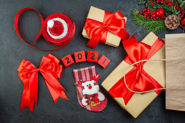 帽子上图是圣诞气氛与美丽的礼物杉木枝针叶树圆锥红丝带和数字圣诞老人帽xsmas袜子在黑暗的背景心情轮子袜子