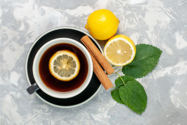 热顶视图一杯茶 表面有肉桂和柠檬 呈浅白色玻璃杯子果汁