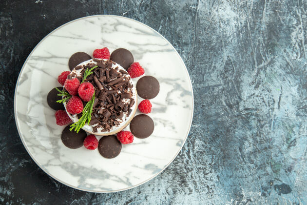 美食顶视图芝士蛋糕与巧克力在白色椭圆形盘子上的灰色表面与自由空间晚餐景观午餐