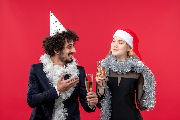 肖像正面图年轻夫妇在红墙派对上庆祝新年圣诞之爱风景微笑年轻夫妇