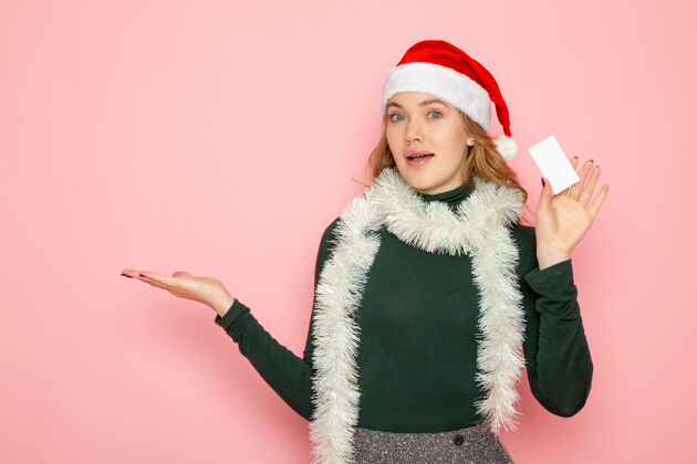 服装正面图年轻女性手握银行卡粉色墙面色彩情感模型节日圣诞新年毛皮外套毛皮看法