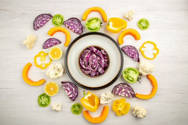 午餐俯视图切碎的红色卷心菜在碗里放在圆盘子上切碎的蔬菜在白色的表面上顶部盘子蔬菜