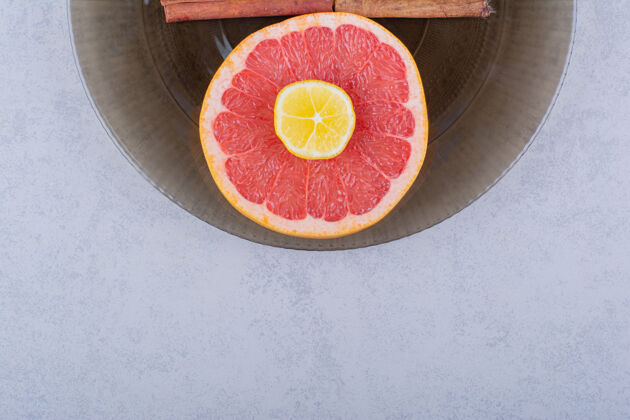 柑橘放在石桌上的一杯新鲜葡萄柚片和柠檬有机葡萄柚生的
