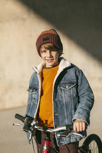 孩子男孩骑着自行车在城市户外玩活动垂直爱好