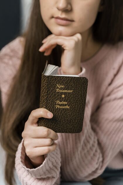 宗教女性阅读新约的正面图精神圣经祈祷