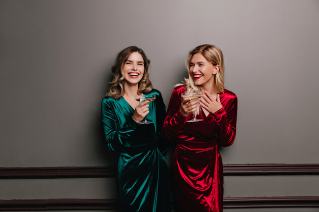 表情穿着绿色服装的浪漫女人在喝酒 风度翩翩的欧洲女人在派对上玩得很开心香槟朋友玩耍