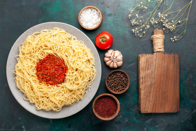 意大利俯瞰意大利面 蓝色表面有肉末番茄酱和调味料午餐肉晚餐