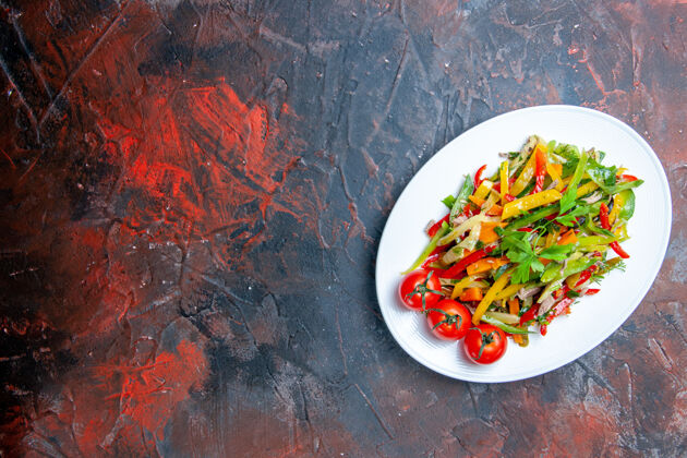 健康俯瞰蔬菜沙拉椭圆形盘子上的暗红色桌子自由的地方用餐午餐胡椒
