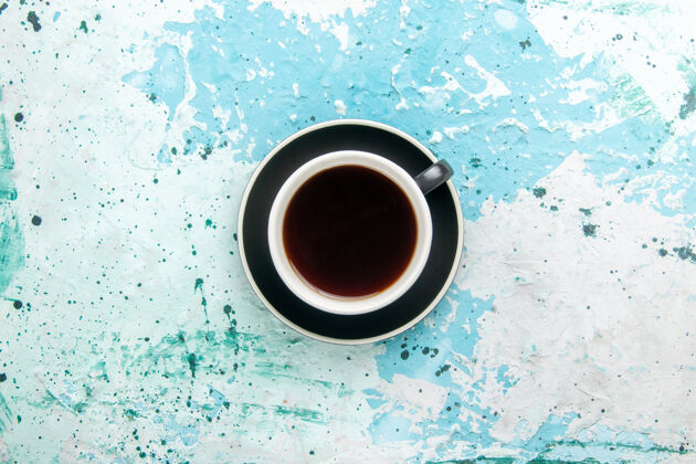 杯子顶视图茶杯内的热饮杯和盘子上的蓝色表面顶部饮料茶