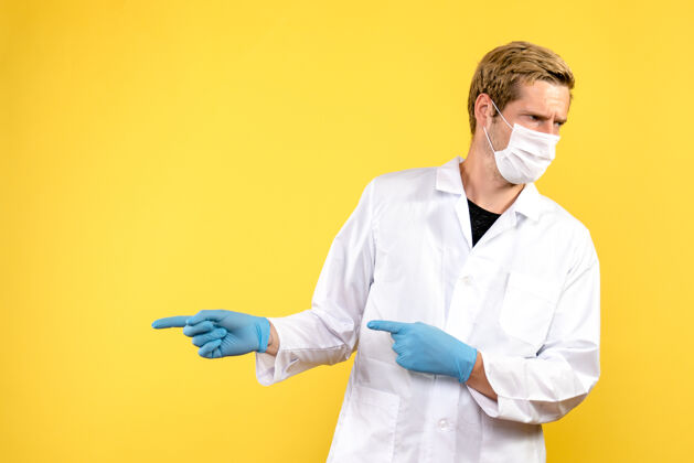 肖像正面图男性医生戴着口罩上黄色背景健康大流行的冠状病毒男性医生实验室外观