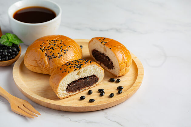堆把烤好的豆沙包放在木盘上 配上咖啡健康的生活方式甜种子