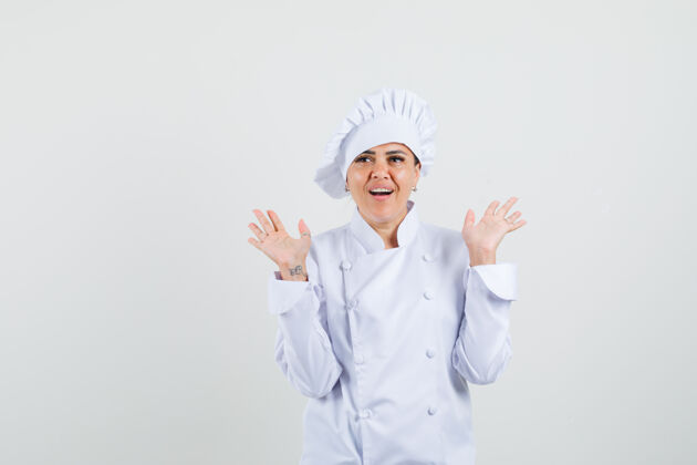 烹饪穿着白色制服的女厨师张开手掌 看上去很惊讶女性柜台惊人