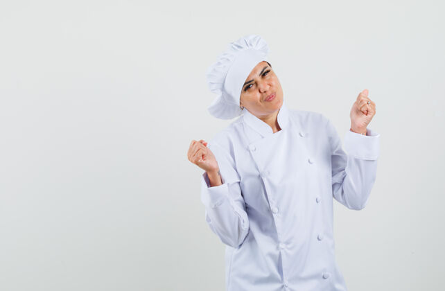 菜肴身着白色制服的女厨师展示赢家姿态 看上去很幸运工作餐厅工作
