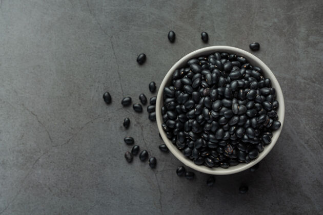 豆类黑豆在白色的小碗里放在深色的地板上食谱水平脉搏