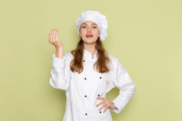 肖像身着白色厨师服的女厨师在绿墙上摆姿势的正面图厨房制服微笑