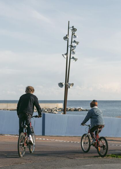 活跃户外骑自行车的儿童朋友的后视图自行车青年娱乐