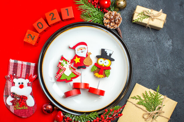号码近距离观看餐盘装饰配件杉木树枝和数字圣诞袜在一个红色餐巾旁边的礼物在一个黑色的桌子上容器袜子托盘