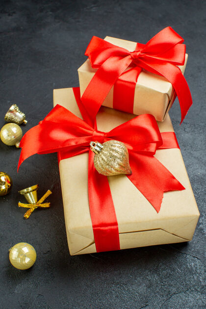 礼品盒礼品盒侧视图与红丝带和装饰配件在黑暗的背景机械装置轮子观点