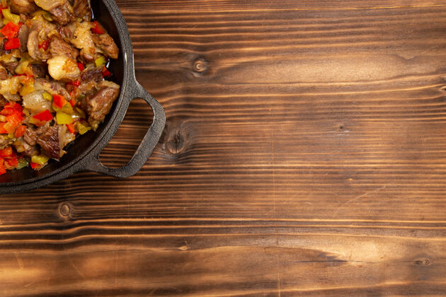 木头顶视图木制表面上有肉和切好的甜椒的熟蔬菜餐顶木板饭