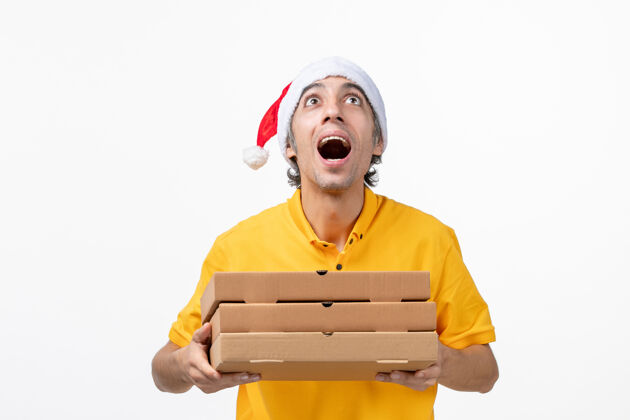 圣诞节正面图白色墙上有披萨盒的男快递员工作制服送货服务笔记本电脑服务工作