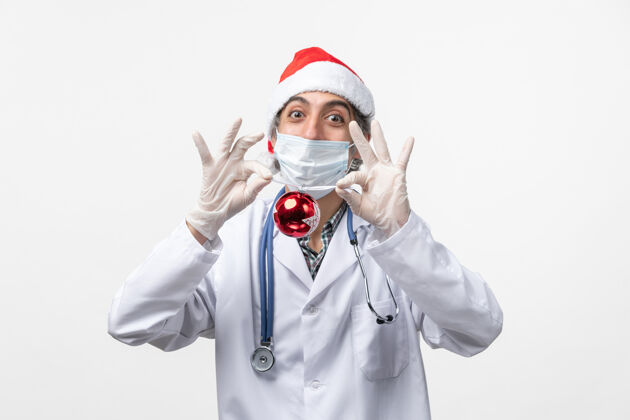 病毒正面图男医生手持新年树玩具健康冠状病毒圣诞节实验室外套成人