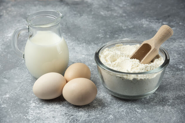 勺子面粉 生鸡蛋和牛奶放在大理石上牛奶面粉做的