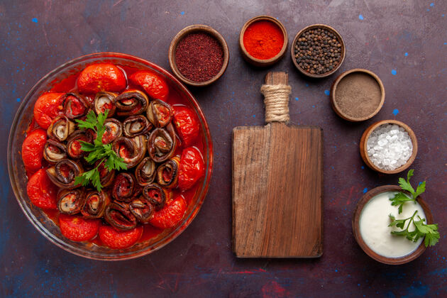 西红柿俯瞰烹饪蔬菜餐美味的西红柿和茄子与调味品在黑暗的表面烹饪生的勺子