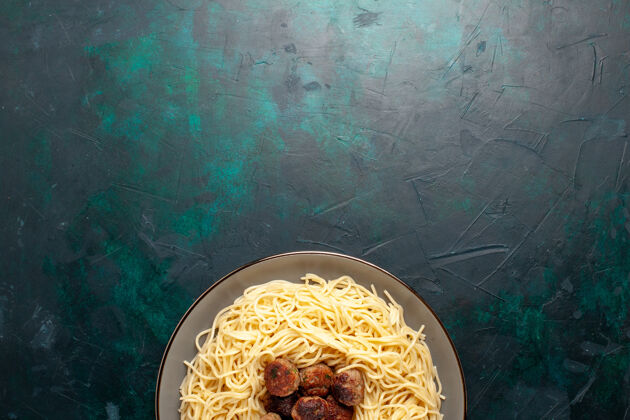 烹饪俯视图煮熟的意大利面食 深蓝色表面有肉丸盘子午餐菜