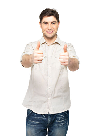 快乐年轻快乐的男人竖起大拇指 在白色的墙壁上随意地贴着牌子休闲看手势