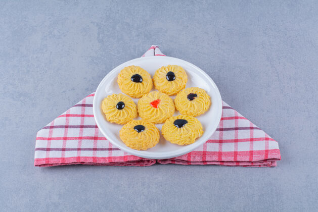 桌布桌布上放着一盘美味的黄色饼干饼干盘子甜食