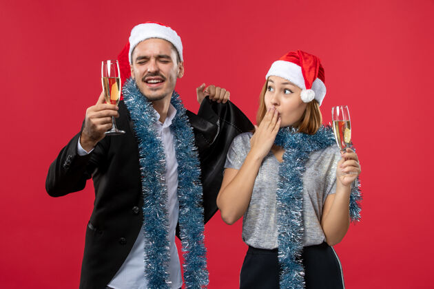 帽子正面图：年轻夫妇在红桌爱心圣诞派对上庆祝新年美丽成人快乐